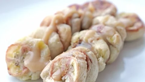 Glazed Banana Pastry Ring with Sliced Creamy Filling and Icing Syrup Drizzle Stock Footage 346328328