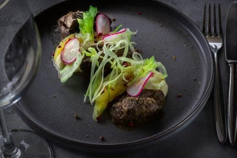 Glazed Beef Cheek with celery puree and ginger pear on gray background in res Stock Photos