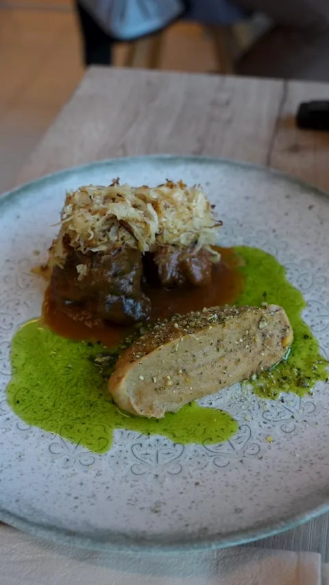 Glazed beef cheek with roasted cauliflower cream and wild garlic oil Stock Footage 338201302