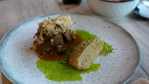 Glazed beef cheek served with roasted cauliflower cream and vivid wild garlic Stock Footage 339087830