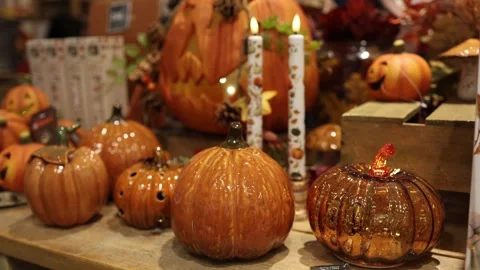 Glazed ceramic pumpkins and amber glass ornaments in a cozy fall display Vidéo 347813031