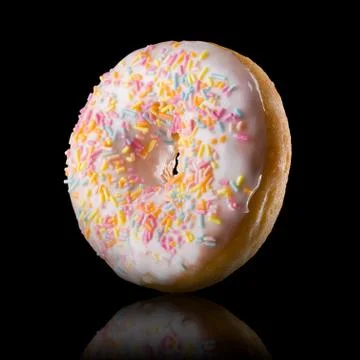 Glazed donut with reflection on a black background rotated in three quarters Stock Photos
