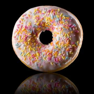 Glazed donut with reflection on a black background rotated in three quarters Stock Photos