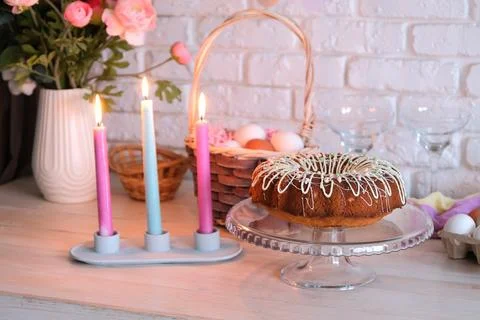 Glazed Easter cake and candles on kitchen counter decorated for Easter Stockfoto's