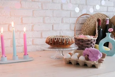 Glazed Easter cake and candles on kitchen counter decorated for Easter Stock Photos