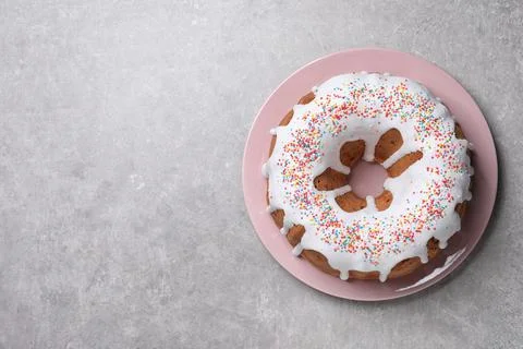 Glazed Easter cake with sprinkles on grey table, top view. Space for text Stock Photos