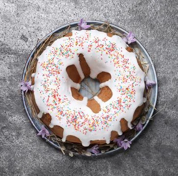 Glazed Easter cake with sprinkles on grey table, top view Stock Photos