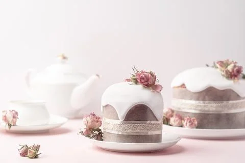 Glazed Easter cakes decorated with dry tea rose flowers on pastel pink Stock Photos