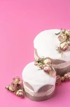 Glazed Easter cakes decorated with dry tea rose flowers on bright pink Stock Photos