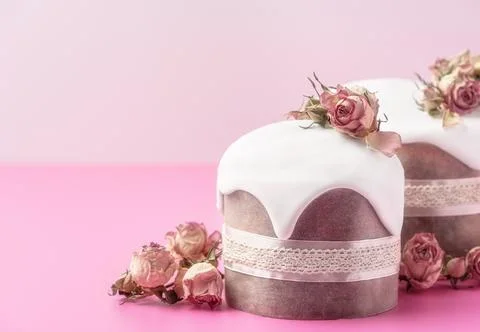 Glazed Easter cakes decorated with dry tea rose flowers on bright pink Stock Photos