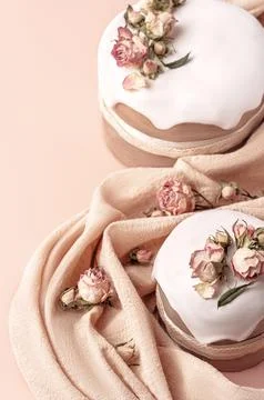 Glazed Easter cakes decorated with dry tea rose flowers on pastel background Stock Photos