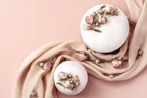 Glazed Easter cakes decorated with dry tea rose flowers on pastel background Stock Photos