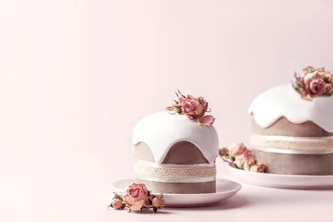 Glazed Easter cakes decorated with dry tea rose flowers on pastel pink Stock Photos