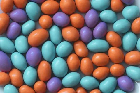 Glazed peanuts of different colors background. Multicolored peanuts texture. Stock Photos