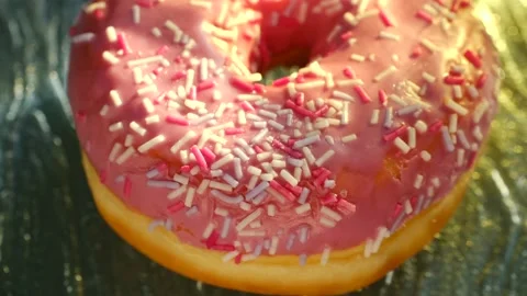Glazed pink sprinkle donut rotating slowly Video stock 337831127