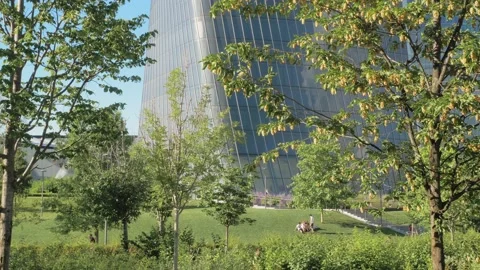 Glazed skyscraper in a park Stock Footage 133672670