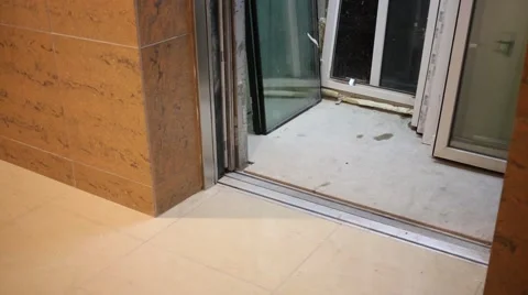 Glazed windows stand in freight elevator and workers bring frame Stock Footage 49711560