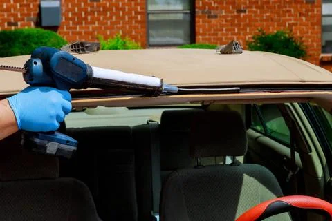  Glazier using silicone tools repairing windshield on a car automobile win... Stock Photos