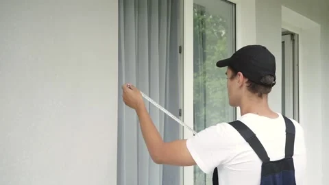Glazier at work. Specialist in installing plastic windows removes dimensions Stock Footage 138569653