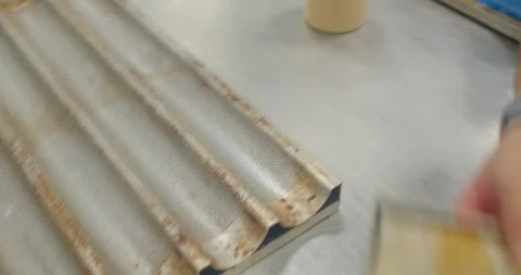 Glazing and racking rows of round dough in commercial bakery production, with Stock Footage 344582481