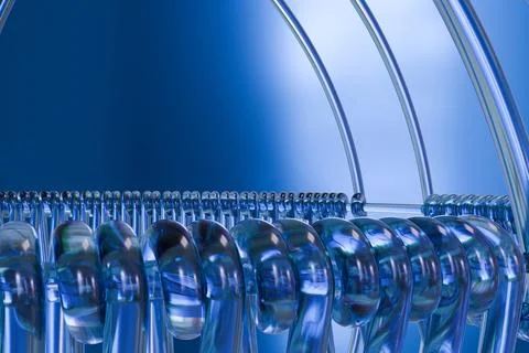 Gleaming, transparent blue tubes, coiled horizontally and arcing vertically.. Illustrazione stock