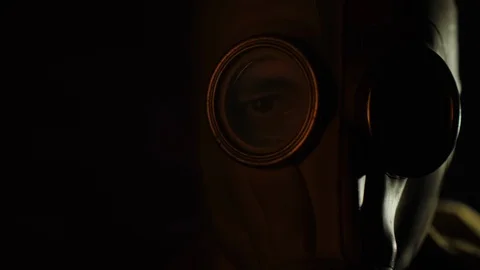 The gleams of the fire are reflected in the eye and gas mask of the man Stock-Footage 121469454