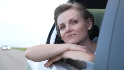 Gleeful lady exploring world by car, fresh rural breeze, waving joyfully, new Stock Footage 312235658