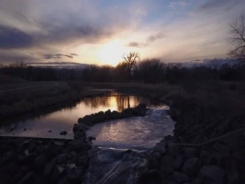 Glide over small rapids to tree and reflection sunset Stock Footage 73533110