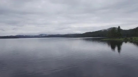 GLIDE OVER WATER WITH MOUNTAINS BACK THERE. Stock-Footage 65318413