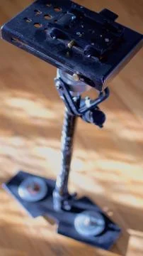 A Glidecam 4000 camera-support system sits on a hardwood floor. Stock Photos
