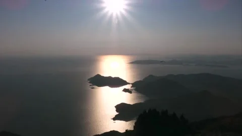 Gliders drift across a sunset sky near Fethiye, Turkey, above island water Stock Footage 339754759
