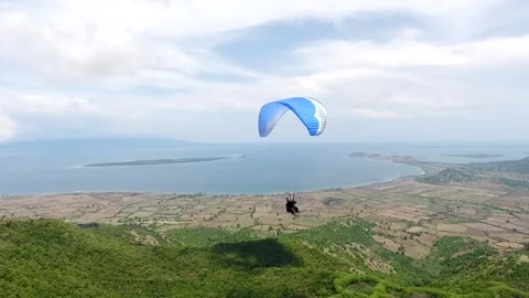 Gliders fly above beautiful sky at Mantar Hill, Sumbawa, Indonesia Stock Footage 131587256