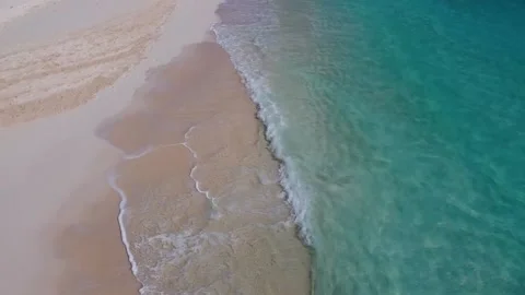 Gliding aerial view above sandy beach with waves. Stock Footage 137534075