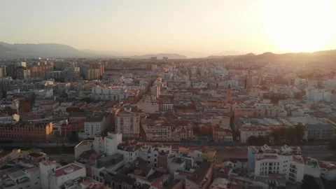 Gliding aerial view above sprawling urban cityscape at golden hour sunset, .. Stock Footage 344059284