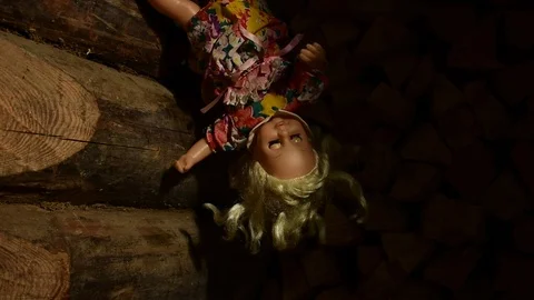 Gliding beam of light gradually illuminates the doll hanging upside down Stock Footage 120246367