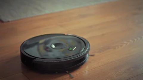 Gliding effortlessly across the floor modern robot vacuum cleaner equipped w Stock Footage 331866249