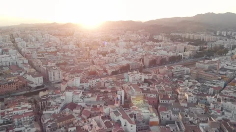 Gliding effortlessly over Malaga city rooftops at golden hour sunset, revea.. Stock Footage 341828683