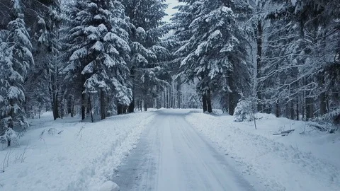 Gliding on the empty mountain road in snowy winter Stock Footage 85897699