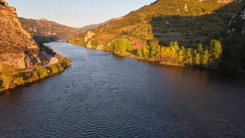Gliding Just Above a Peaceful River Into the Golden Evening Stock-Footage 337264076