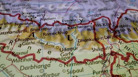 Gliding macro view from india and nepal to mount everest on a physical atlas map Stock Footage 341699116