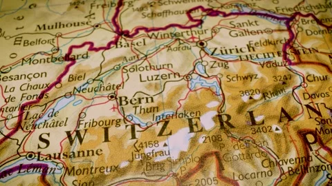 Gliding macro view over physical atlas map showing Switzerland Stock Footage 340917189