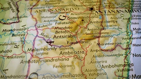 Gliding macro view over physical atlas map leading to Antananarivo, Stock Footage 341751899