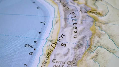 Gliding macro view over physical atlas map leading to the Atacama Desert Stock Footage 341752080