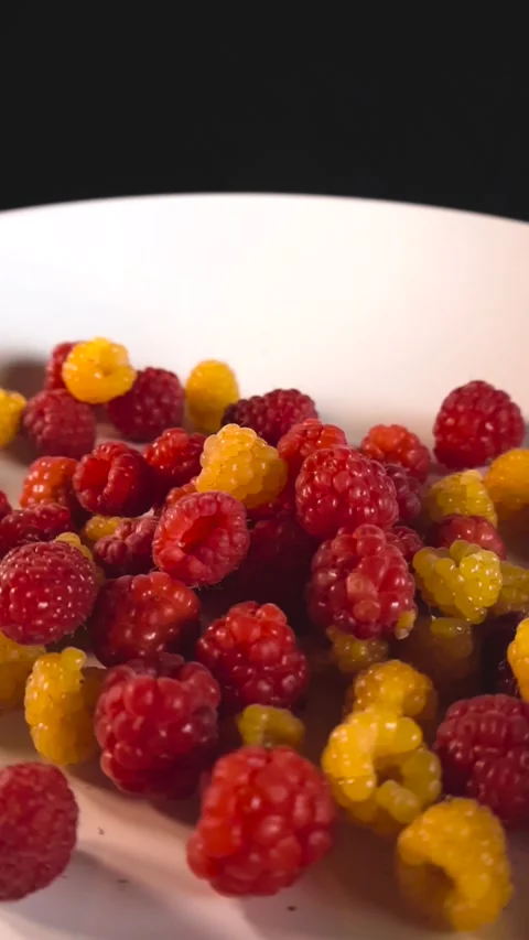 Gliding over Close of Yellow and Red Raspberry Mix on a Plate Stock Footage 341399085