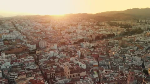 Gliding over Malaga city rooftops at golden hour sunset, revealing sprawlin.. Stock Footage 344052121