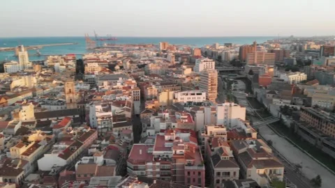Gliding over Malaga's urban sprawl and river towards the Mediterranean Sea .. Stock Footage 344052104
