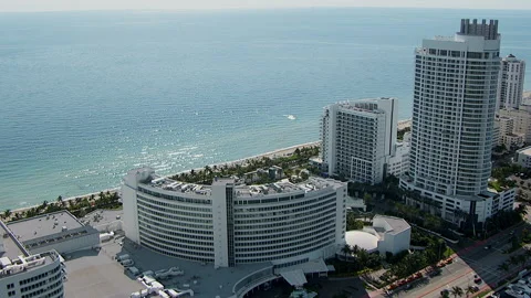 Gliding over Miami high-rises on beach Stock Footage 136199385