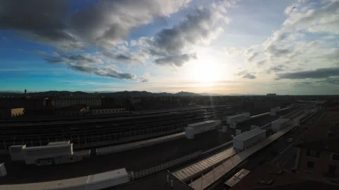 Gliding Over Urban Rail Yard at Sunrise with Dramatic Cloudy Sky Stock Footage 340555468