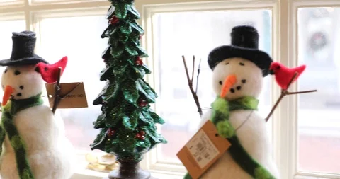 Gliding Pan of Two Modern Stylized Snowman Figures on a Window Sill Stock Footage 121541667