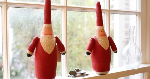 Gliding Pan of Two Modern Stylized Wooden Santa Claus Figures on a Window Sill Stock Footage 121541678